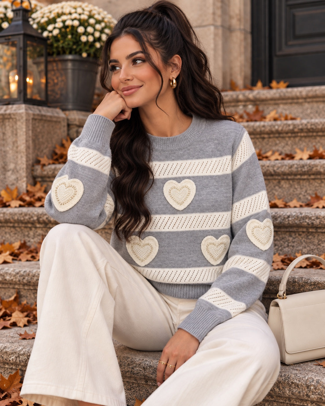 Pull gris et écru à cœurs perlés, porté assis
